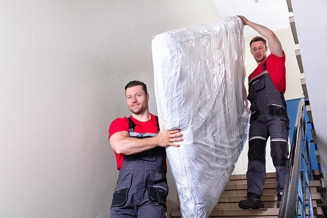 two people disposing of box spring from bedroom in Independence